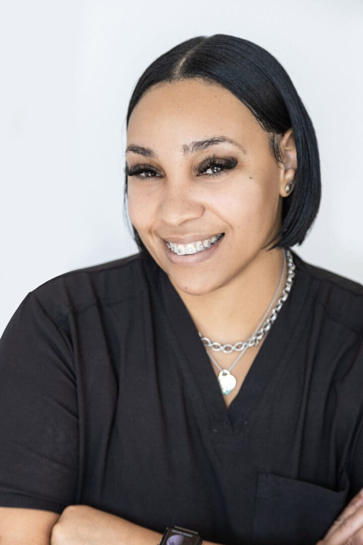 Smiling person with short hair and braces.