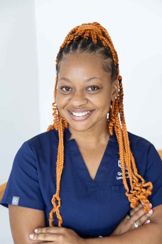 Smiling person with braided orange hair.