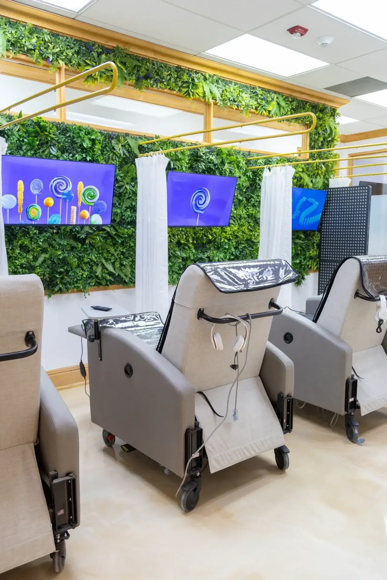Medical chairs with screens and green decor.