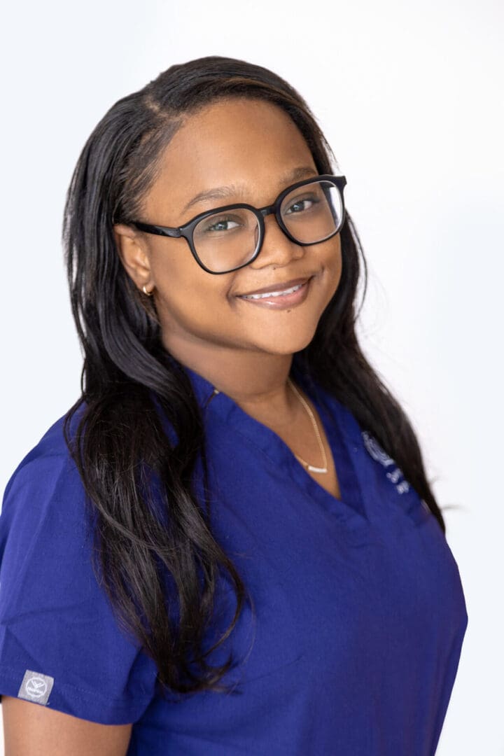 Smiling woman in blue medical scrubs.