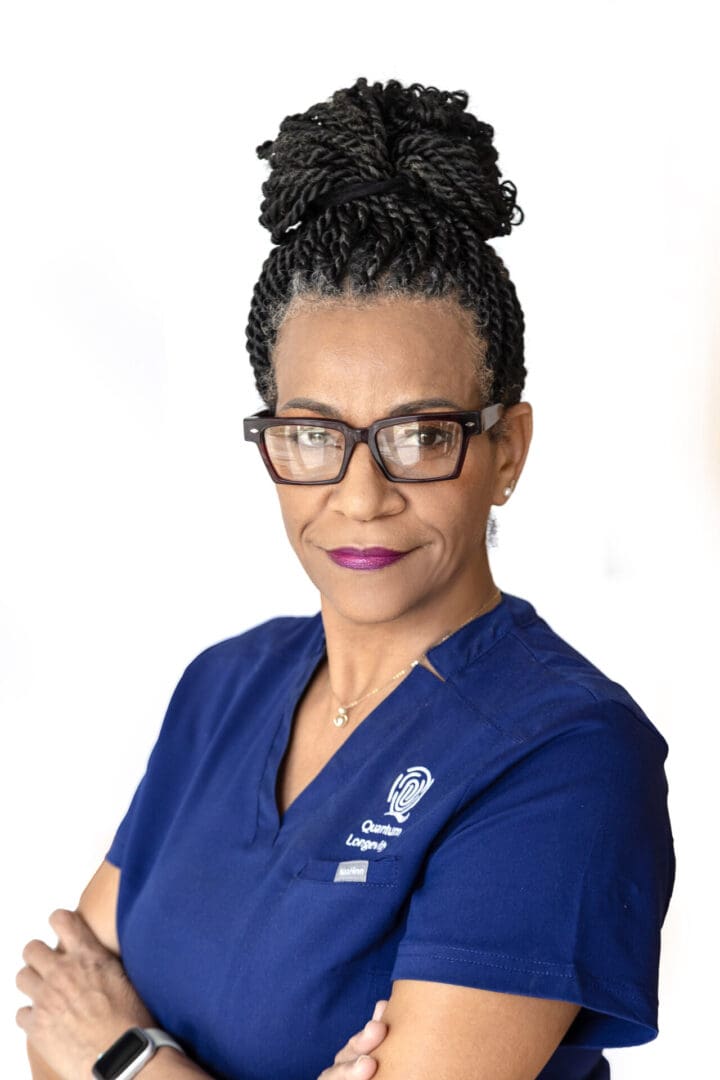 Person in blue scrubs with glasses.