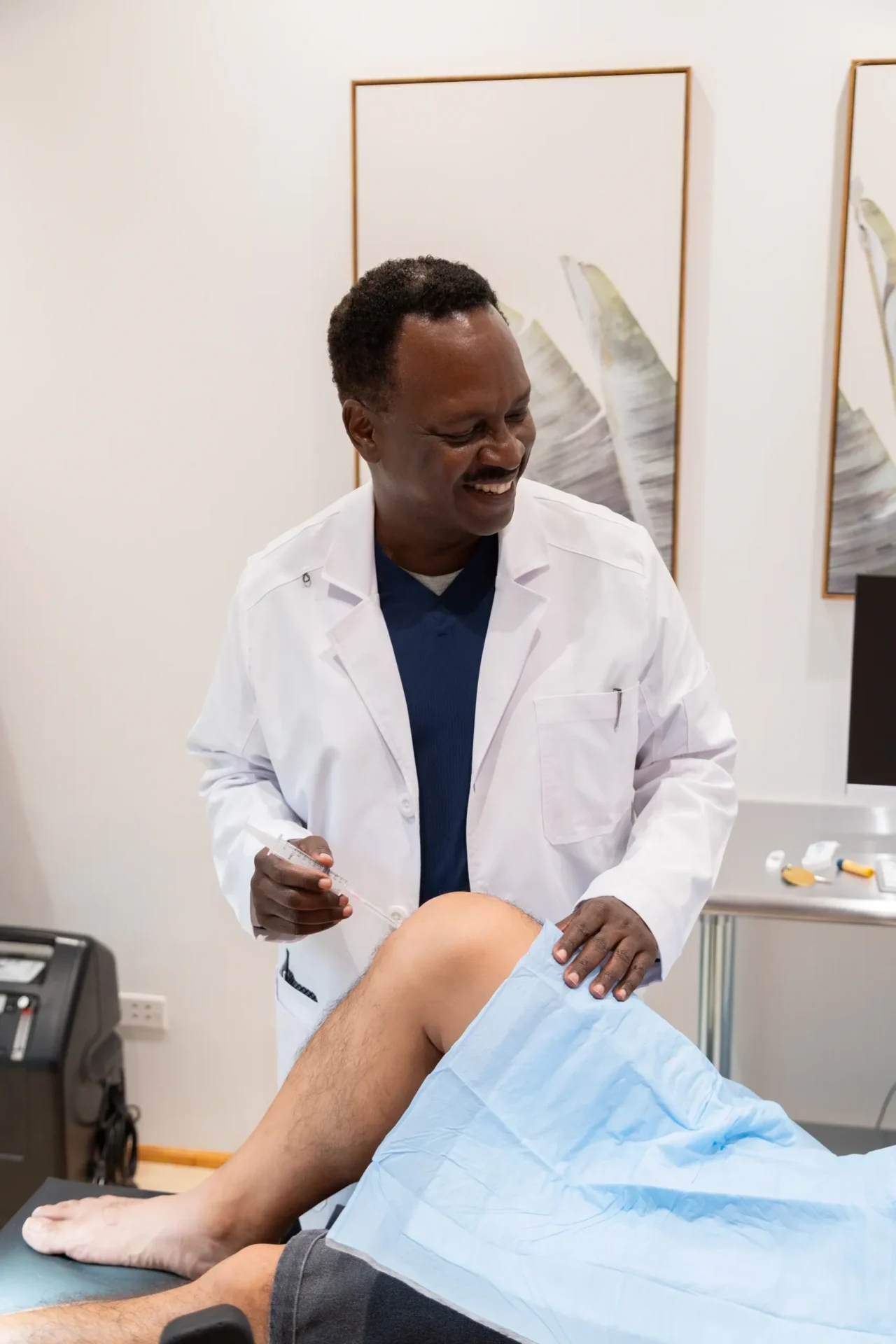 Doctor examining patient's knee in clinic.