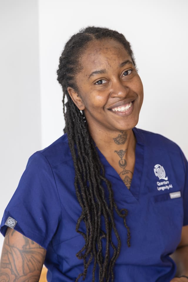 Smiling person in blue medical scrubs.