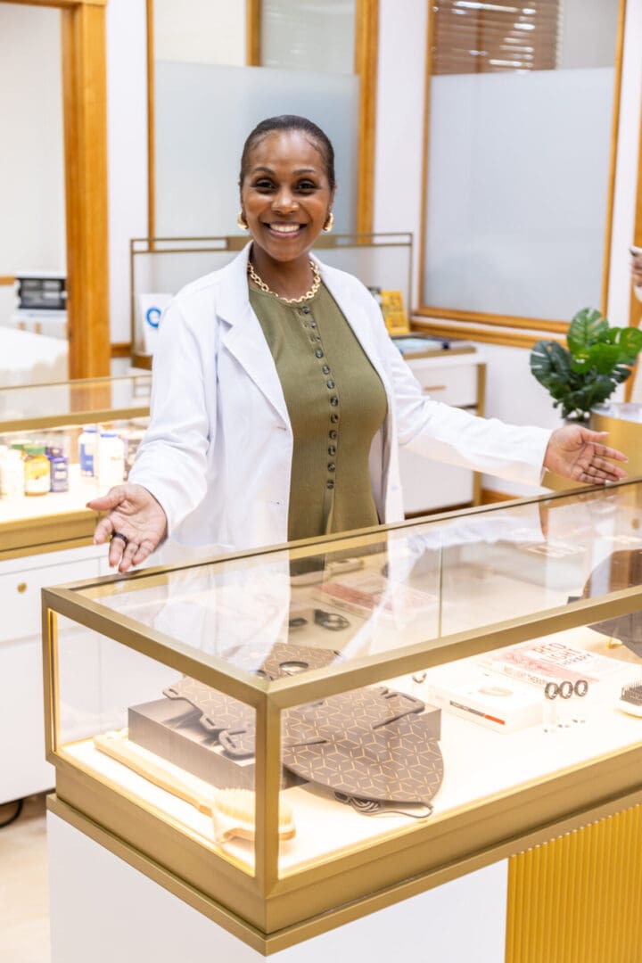 Smiling woman in store with display case.