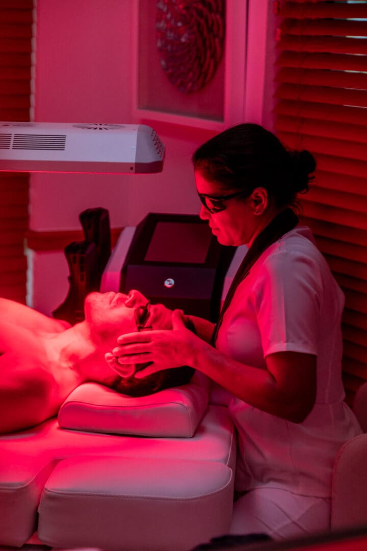 Person receiving light therapy treatment in clinic.