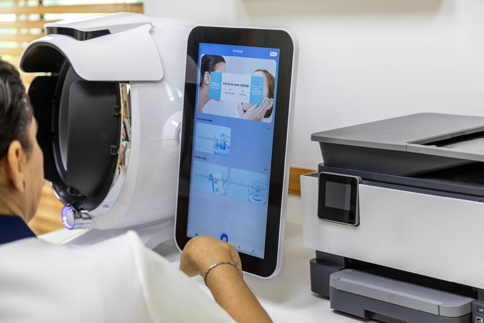 Person using touchscreen near office equipment.